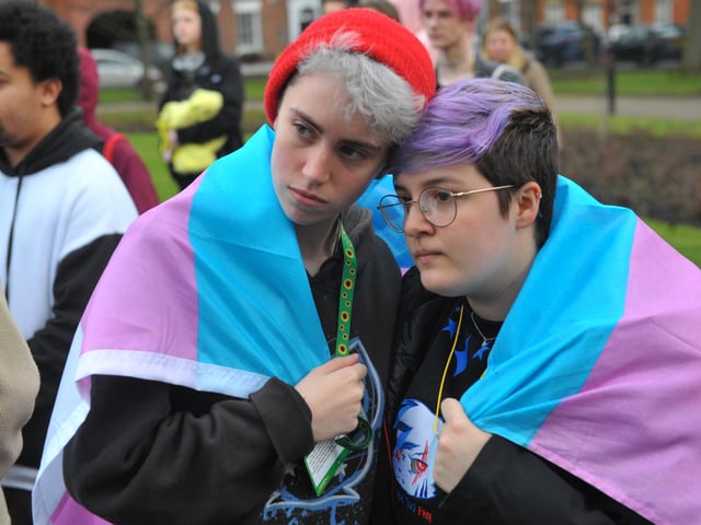 Two of the hundreds of people who turned out for the vigil in City Square, Leeds. Draped around their shoulders is the transgender flag, with its distinctive blue, white and pink stripes.