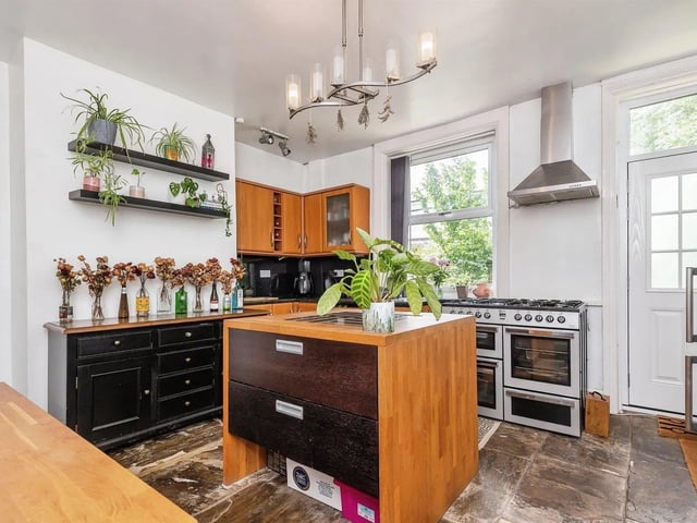 The modern fitted kitchen has a gas hob, stainless steel sink, useful breakfast island and plumbing for an automatic washer.
