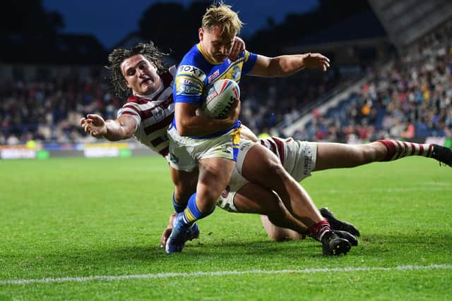 Rhinos' Brad Dwyer beats Liam Byrne, of Wigan, to score Leeds' sixth try. Picture by Jonathan Gawthorpe.