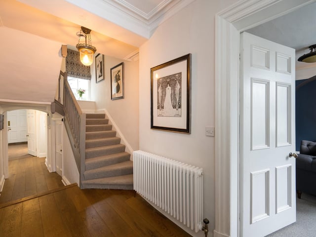 Doors to ground floor rooms open from the hallway, where there is a carpeted staircase up to the first floor.