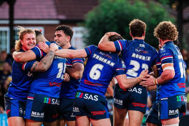 Wakefield Trinity players celebrate after Caleb Hamlin-Uele's try gave them a 12-0 lead against Leeds Rhinos. Picture by Alex Whitehead/SWpix.com.