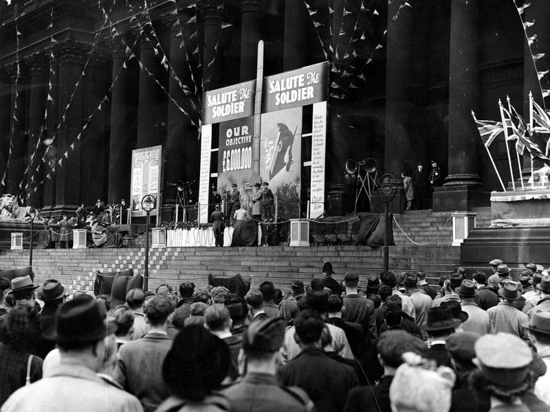 A view of Leeds Town Hall, Major General Shears is making a speech. Behind him is an indicator to mark the progress of the appeal for funds. The target was £6,000,000, the final total was £6,848,594.