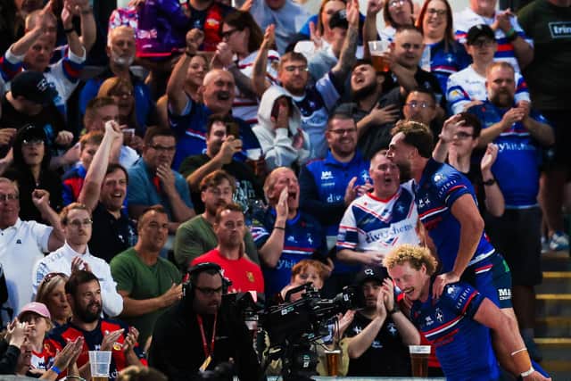 Lachlan Walmsley celebrates with Josh Rourke and Wakefield Trinity fans after scoring in the 52-14 hammering of Castleford Tigers. Picture by Alex Whitehead/SWpix.com.