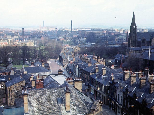 A view north along Queen Street from the bell balcony of Morley Town Hall, using a camera with wide angle lens. In the centre the properties on the triangular plot are at the junction with Troy Road. The greenery to the left is Scatcherd Park and over the roof tops to the right the Church of St. Mary's-in -the Wood can be seen in Commercial Street. Pictured in April 1965.