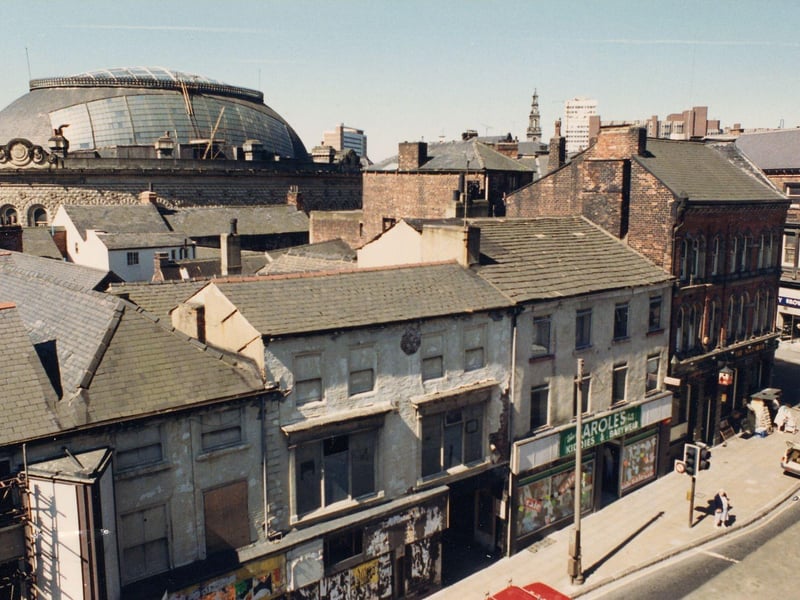 Kirkgate in October 1990. Carole's childrenswear, is advertising a sale. On the corner by the junction with Call Lane, is the Scotsman public house. Across the road, No.2 Call Lane, Henry Brown Electrical Ltd is just visible. The dome of the Corn Exchange can be seen in the background.