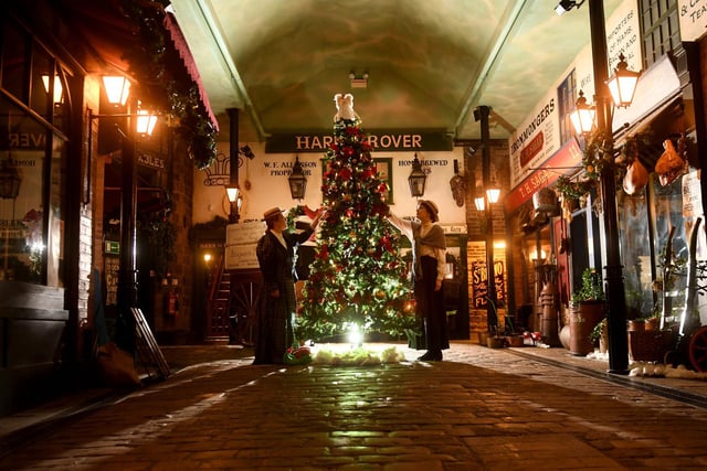 Decorating the Christmas tree in Abbey House Museum in Victorian-era clothing are Sarah Allen (left) and Sara Merritt (right). Abbey House Museum is local to Leeds and social history with Victorian streets and nostalgic galleries.