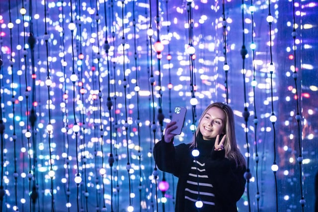 Dawn Farmer takes a selfie in front one of the light installations.