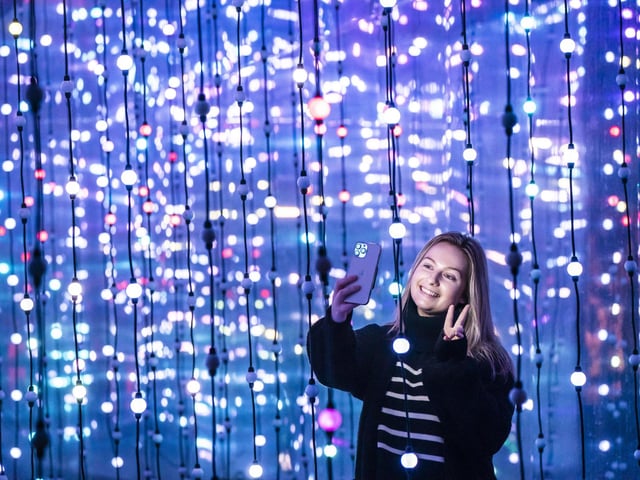 Dawn Farmer takes a selfie in front one of the light installations.