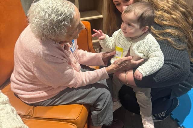 Resident at HC-One’s Colton Lodges Care Home with child from Songs & Smiles baby group