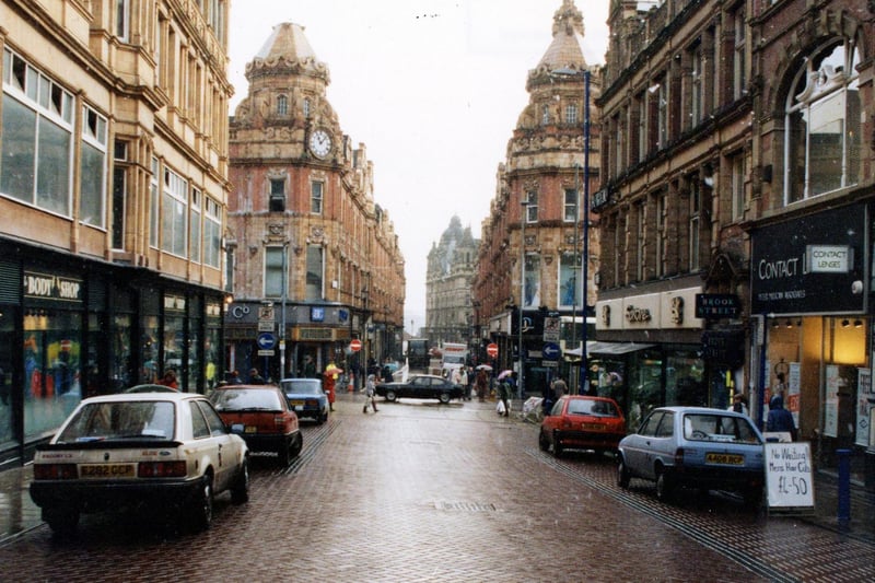 Albion Place looking east towards the junction with Briggate and King Edward Street. On the left is the Body Shop cosmetics, with Dunn & Co, menswear across the road. On the right is Peter Millican, opticians, then Brook Street Bureau employment agency and Saxone footwear, with Debenhans department store beyond the junction.