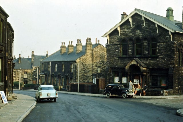 The building being used as a polling station during local elections about May 1965 is Morley Friends' Adult School. This stood at the junction of Ackroyd Street, Cross Peel Street and Charles Street, until it was closed in 1998. Since then it has been thoroughly cleaned up and converted into flats, with another storey made out of the high upstairs hall. At the left hand side of the building two former wooden shops, one a gents' hairdresser, have been pulled down.