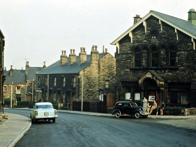 The building being used as a polling station during local elections about May 1965 is Morley Friends' Adult School. This stood at the junction of Ackroyd Street, Cross Peel Street and Charles Street, until it was closed in 1998. Since then it has been thoroughly cleaned up and converted into flats, with another storey made out of the high upstairs hall. At the left hand side of the building two former wooden shops, one a gents' hairdresser, have been pulled down.