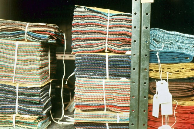 Racks of cloth in the warehouse. The warehouse where finished cloth was awaiting transport to a customer also kept a stock of pattern books and sample lengths. Cloth for the pattern books was cut to the same dimensions and given saw tooth edges to prevent fraying. If a customer wanted to see a garment made up from the cloth before placing an order they were sent a longer length of cloth as seen on the right. Sometimes valued customers sent in suggestions as to the type of pattern they would like and the firm made special sample lengths to try to fit the specifications, but this only occurred if trade was slack.