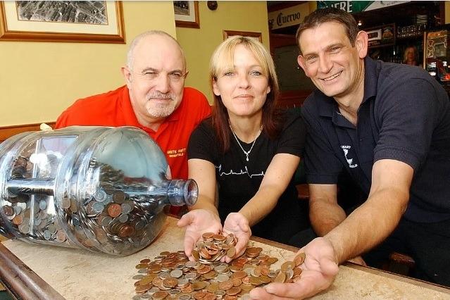 Water container full of cash for Wakefield Hospice - the White Hart Westgate, Ian Bain (landlord) Alison and Dave Lund. 2004.