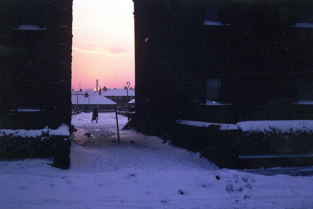 A winter sunset seen through blocks of terrace houses on Springfield Lane in February 1963.