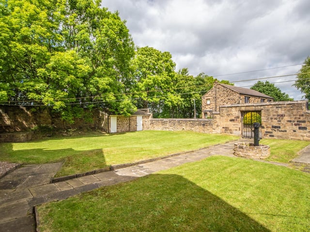 Stone walls and mature trees and shrubs edge the gardens.