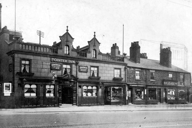 The Pointer Inn public house, with hanging sign for John Smiths 'Magnet Ales', landlady Mrs Catherine Golden. At this time, this was listed as North Street, name being changed after road works were completed. So the Pointer was 236 North Street, then to the right, number 234 fruit shop run by Ernest Crosby, number 232 Frederick Freemantle selling hosiery. At number 230 Myers Lewis, ladies tailor. Next 228 Murphys Hardware shop, last in row 226 Myer Wolf furniture shop. Behind number 226 is an artists impression of the facade of the Sheepscar library which was opened in 1938. At the junction of Chapeltown Road and Roundhay Road. Pictured in June 1927.