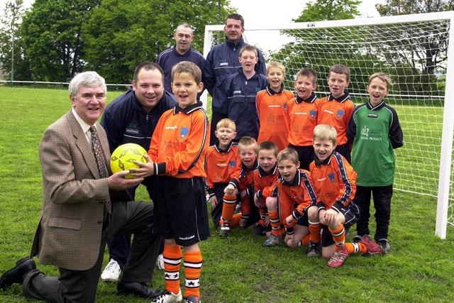 Sponsor Ted Hanley with Bramley Phoenix U-9s captain Sam Parker and manager Darren Wood with players wearing the new kit. Pictured in May 2003.