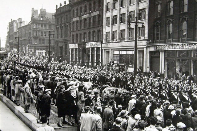 People line The Headrow in 1942 to watch the parade launching a fund raising campaign to help build a new Ark Royal after the previous ship was sunk in combat.