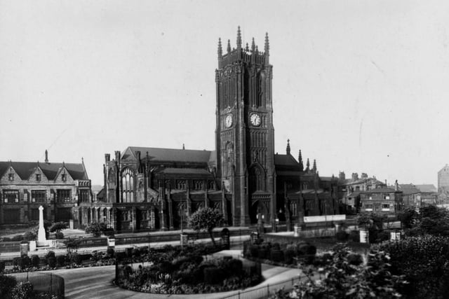 St. Peter's Church on Kirkgate. On the opposite side of the road is a park with circular flower beds behind metal railings. Pictured in April 1950.