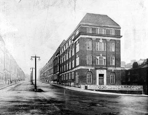 This view looks along Eastgate towards Vicar Lane and The Headrow in May 1935. Street lamps stand on traffic islands and stretch off into the distance. The building at the right is the Kingston Unity friendly society headquarters. To the far right is D Smith's Boat repairing depot. The buildings seen further back on the right and all along the left side are plans that have been drawn in; these were not actually built until after the war.