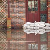 Sandbags outside front door of flooded house. Photo: Adobe