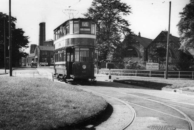 A view of the roundabout at Bramley Town End, seen from Henconner Lane and looking west towards Stanningley Road. A tram, Chamberlain no. 420, bound for the Corn Exchange on route 14, is seen in the centre. The curved tram track in the foreground leads off to Bramley Town End Depot. In the background on the right is the former Good Shepherd School, seen here advertised as "To Let or For Sale", which is now (2010) a veterinary practice. Further back towards the left are Springfield Mill and Brown's Mill on Stanningley Road.