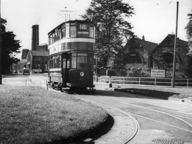 A view of the roundabout at Bramley Town End, seen from Henconner Lane and looking west towards Stanningley Road. A tram, Chamberlain no. 420, bound for the Corn Exchange on route 14, is seen in the centre. The curved tram track in the foreground leads off to Bramley Town End Depot. In the background on the right is the former Good Shepherd School, seen here advertised as "To Let or For Sale", which is now (2010) a veterinary practice. Further back towards the left are Springfield Mill and Brown's Mill on Stanningley Road.