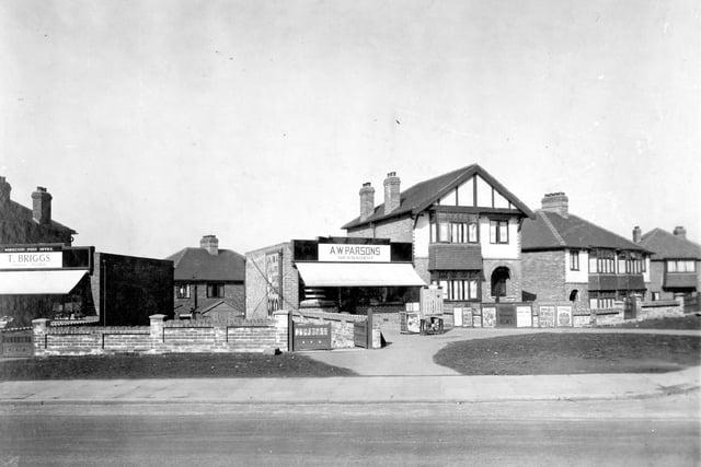 General grocers and Whitecote Post Office on Leeds & Bradford Road in March 1935. Next door is a detached house and newsagents shop. The side of the shop has an OXO sign which is absent from a later photo. A cigarette machine and posters for publications include 'John Bull' magazine with heading 'Infamous Marriage Hoaxer'.