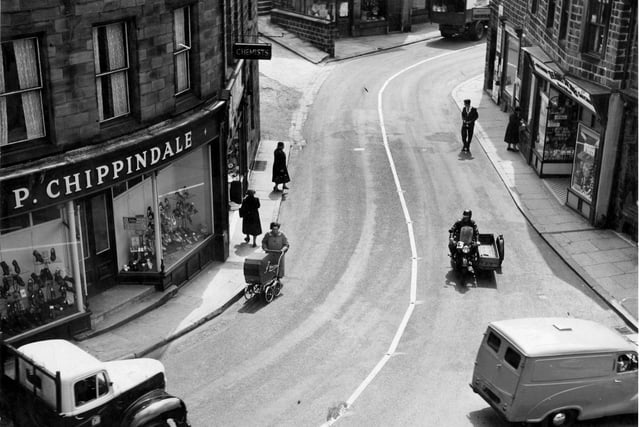 Ivegate in the 1950s. On the left is Paul Chippindale's shoe shop, next chemists shop which was formerly Hardmans then branch of Timothy White and Taylors. Next on the bend of the road, wool shop and Coys corn merchants. To the right, newsagents shop which for years was the business of the White family. Dora White married Sydney Howard, local musical comedy star and comedian. When returning to Yeadon they would stay here with the White family. Last on the right is the Abbey Stores, grocers.