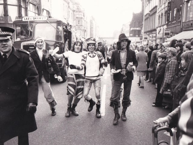 A big crowd watches Leeds students' rag procession move through the city centre in December 1975. Vikings, flour graders and 'patients' bandaged from head to toe reclining in beds were just a few of the intriguing sights.