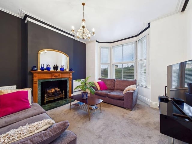 The living room has a feature fireplace with heath and surround, and is carpeted throughout.