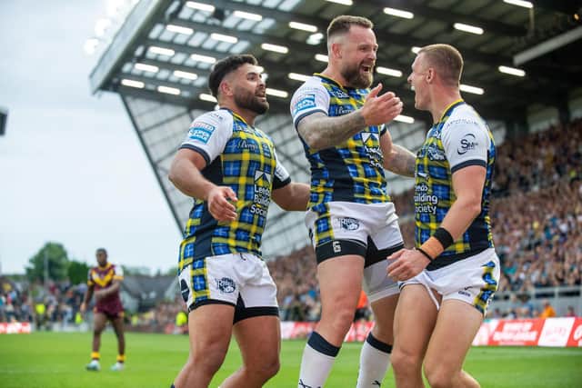 Ash Handley, right, celebrates with Rhyse Martin, left and Blake Austin after scoring for Rhinos against Giants.  Picture by Bruce Rollinson.
