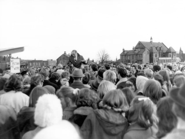 A meeting of striking workers on Woodhouse Moor in February 1970. Five thousand clothing factory workers rejected on the offer of immediate negotiations on their claim if they returned to work. Charlie Taylor was chairman of the unofficial strike committee. St Marks School can be seen in the background.