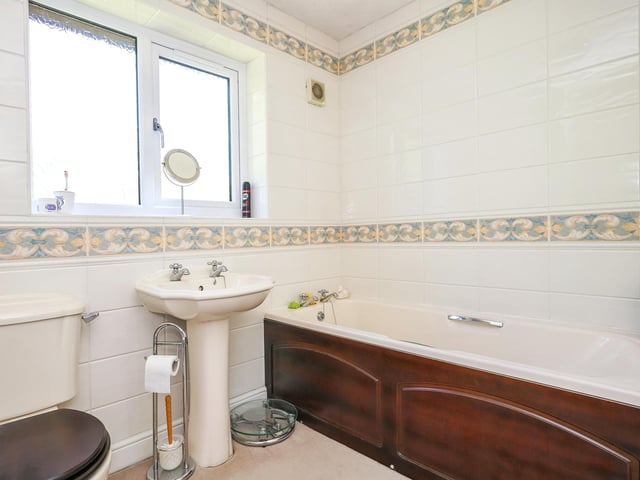 The four piece house bathroom has a fantastic wooden framed bath.
