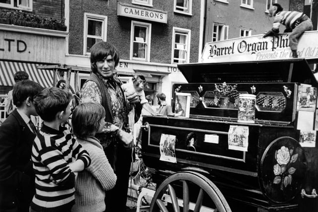 Youngsters gather round Phil, the barrel-rogan man, who, with his monkeys, was giving a performance in St. Sampson's Square in July 1971.
