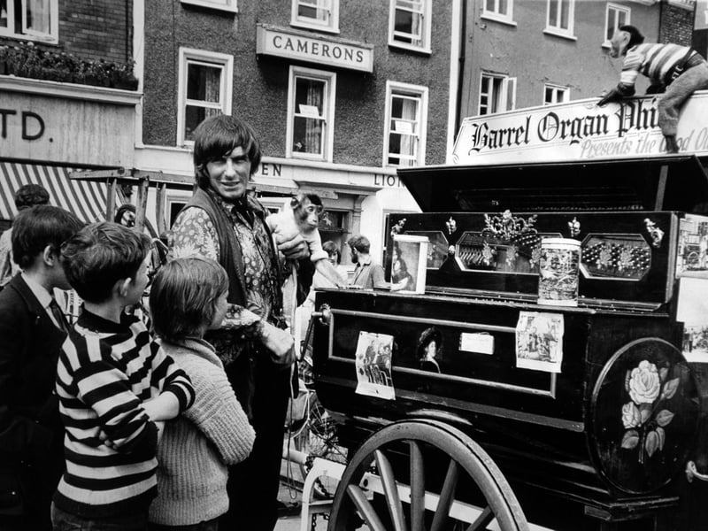 Youngsters gather round Phil, the barrel-rogan man, who, with his monkeys, was giving a performance in St. Sampson's Square in July 1971.