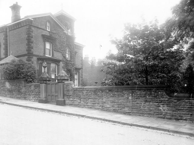 Detached property, 'The Tower' on Woodhouse Cliff. This view shows stone boundary wall, garden, entrance gate with stone pillars, lamp and house name. There are 'To let' signs in the windows.