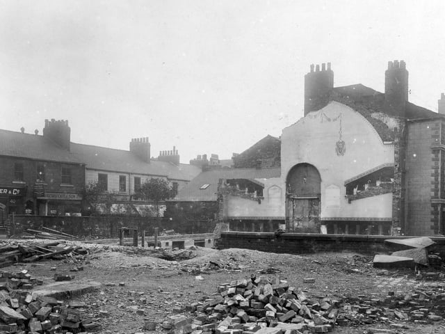 Wasteland on Merrion Street, where a building has been demolished. In main view is the side of the Victoria Club, 51c, New Briggate - now Nash's Fish Restaurant. Shops along Merrion Street are; Parker and Co, Cabinet Makers, Brownfoot and Son, Venetian Blind Makers, Solomon Wolfson, furniture dealer. Pictured in July 1929.