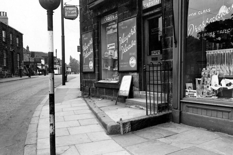 David Burton's sweets and tobacco shop on Otley Road pictured in May 1952. Next door is Mrs Mabel Trimmer's dressmaking shop. Burton's shop has adverts for Player's Craven A and Will's Capstan outside.