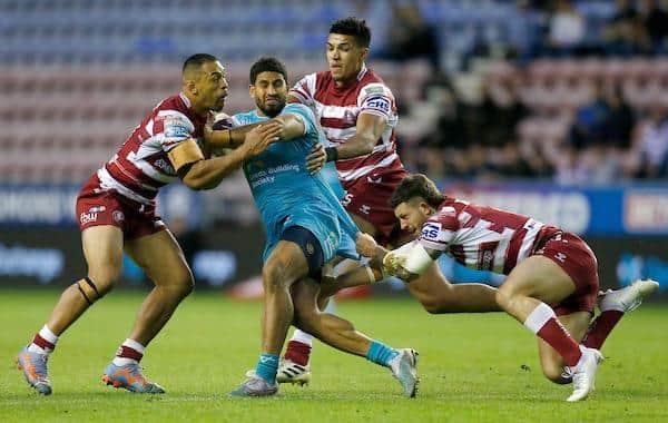 Rhinos' Nene MacDonald is tacvkled by Wigan's Willie Isa, Kai Pearce-Paul and Cade Cust. Picture by Ed Sykes/SWpix.com.