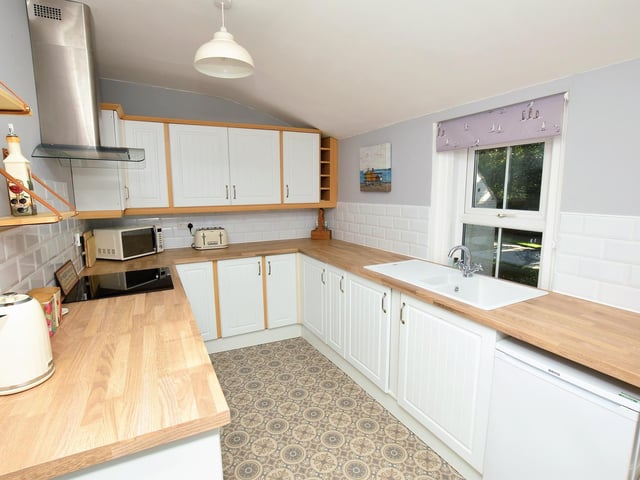 The modern kitchen has fitted units and appliances.