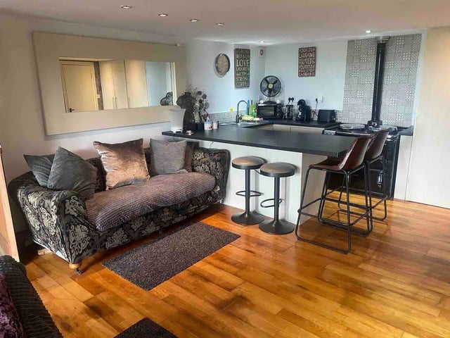The cottage has an open plan kitchen with a breakfast bar and seating area. The kitchen is fitted with an Aga cooker.