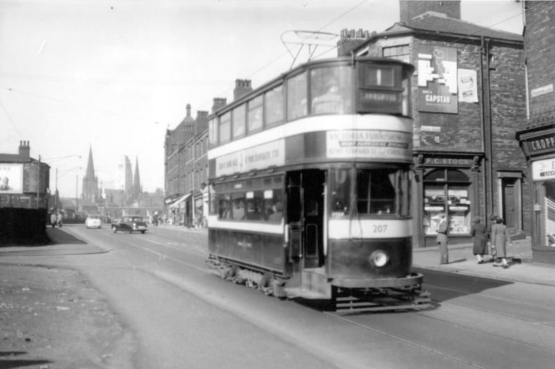 Tram 207 travelling along Woodhouse Lane on route no 1 to Lawnswood in September 1954. F.C Stock, dispensing chemist, can be seen on right at 106 Woodhouse Lane on Junction with Exeter Street. Trinity Congregational Church, Emmanuel Church and Parkinson Building visible in the distance.