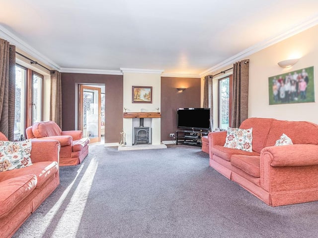 A wood burning stove, set into the chimney breast, is a focal point within the large living room.