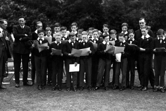 Photo taken during a garden party at Meanwoodside in July 1926. The choir boys of Leeds Parish Church are assembled to sing to guests, included were the Clergy, Wardens and Friends of the Parish Church. On the left is H. Bacon Smih who was choir secretary, treasurer and a church warden, next with arms folded, is Col. E. Kitson Clark, who lived at Meanwoodside. To the right, standing behind the boys is Canon Thompson Elliot, Vicar of Leeds.