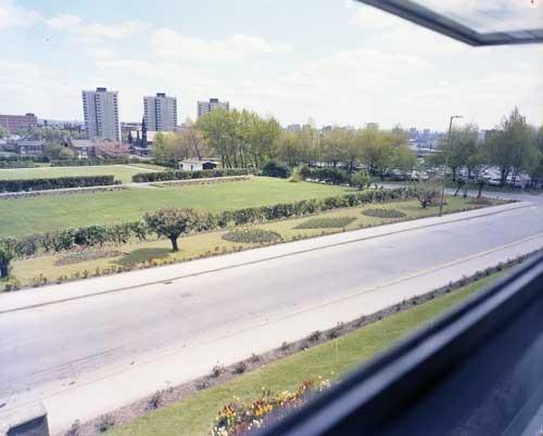 Burton's company gardens taken from an open window at Burton's factory on Hudson Road in May 1977. The view looks towards Burmantofts Street and the city. Saxton Gardens and the Town Hall can be seen in the background. St Agnes' Church can be seen to the left of the image.