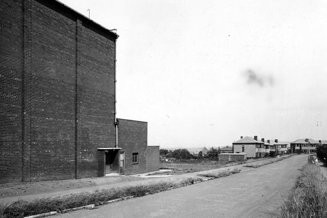 Looking east along Southleigh Crescent in July 1945. The large, brick building in the foreground, is the side of the Rex cinema which fronts onto Gypsy Lane. Streetlamps and a child are visible in the background.