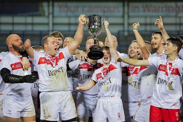 Rhinos' Scott Gobin, second from left, lifts the PDRL World Cup after England's win over New Zealand. Picture by Alex Whitehead/SWpix.com.
