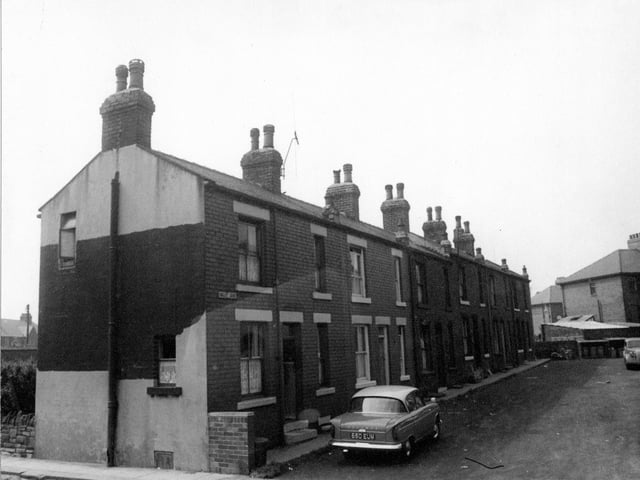 Tingley Court taken from Bridge Street in 1964. Street sign clearly visible, dustbins at end of street with backs of garages for adjacent properties on Britannia Road. Television aerial on roof of number 6 Hillman car reg: 660 EUM, parked in foreground.